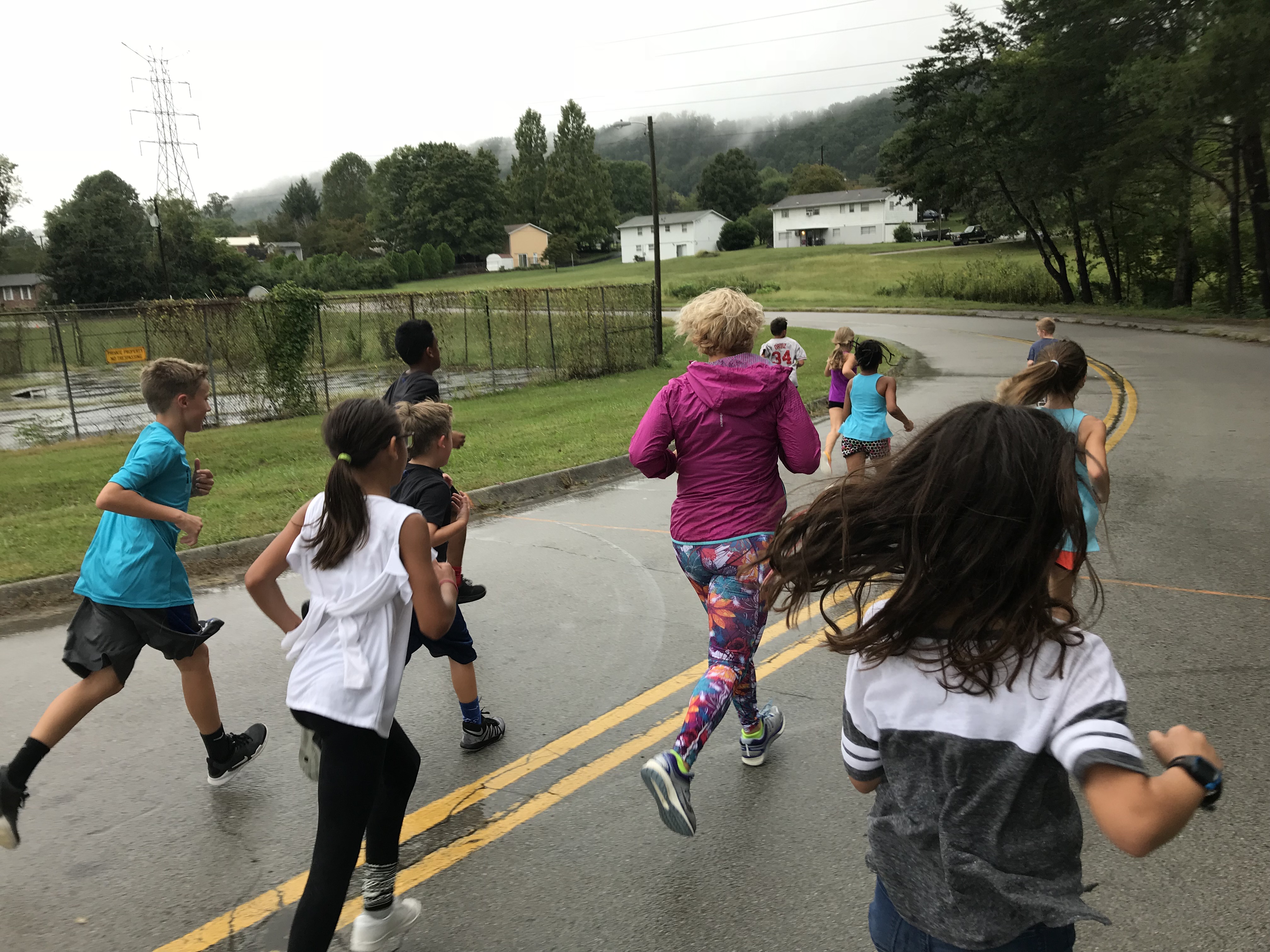 Muna Rodriguez, a parent and assistant coach for the Adrian Burnett Elementary cross-country team, runs with the team on Sept. 26, 2018. 